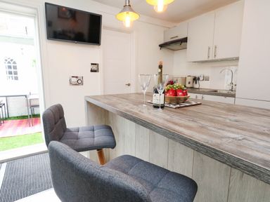 A kitchen with a bar table and chairs at Flat 1, 2 Wooperton Street Weymouth