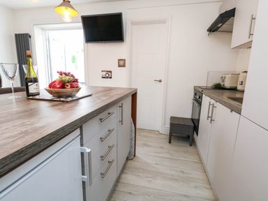 A kitchen with a fruit bowl and bottle of wine at Flat 1, 2 Wooperton Street in Weymouth