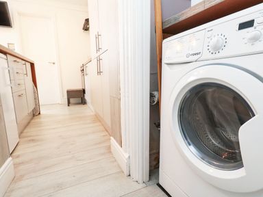 A kitchen with a washing machine and cabinets at Flat 1, 2 Wooperton Street Weymouth