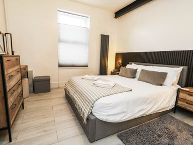 A bedroom with a bed and dresser at Flat 1, 2 Wooperton Street Weymouth