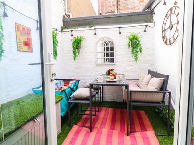 A small outdoor seating area with a table and chairs at Flat 1, 2 Wooperton Street Weymouth