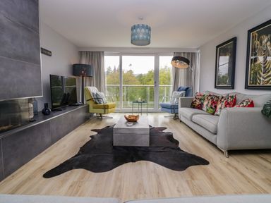 A living room with a coffee table and television at 10 Rayrigg Rise Bowness-On-Windermere
