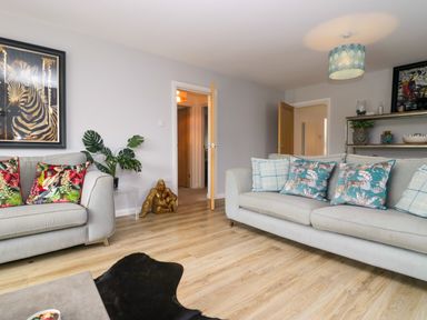 A living room with a sofa and artwork at 10 Rayrigg Rise Bowness-On-Windermere
