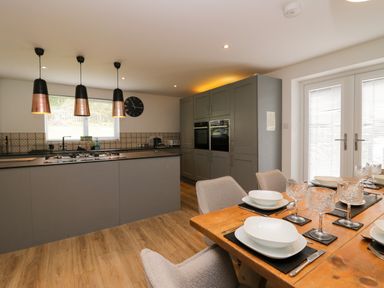 A kitchen with appliances and dining area at 10 Rayrigg Rise Bowness-On-Windermere
