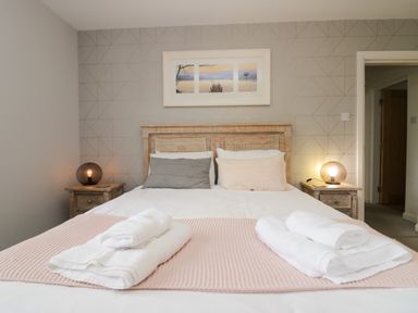 A bedroom with a bed and bedside tables at 10 Rayrigg Rise Bowness-On-Windermere