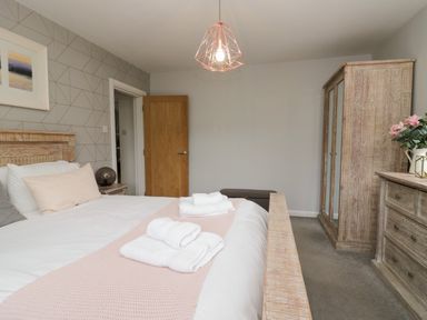 A bedroom with a bed and wardrobe at 10 Rayrigg Rise in Bowness-On-Windermere