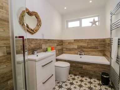 A bathroom with a sink and bathtub at 10 Rayrigg Rise Bowness-On-Windermere