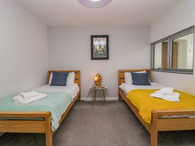 A bedroom with two beds and a nightstand at 10 Rayrigg Rise Bowness-On-Windermere