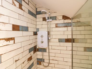 A shower with tiles and control panel at 10 Rayrigg Rise Bowness-On-Windermere