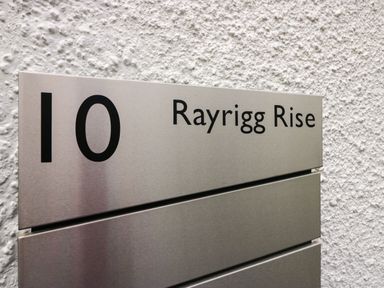 A metal sign displaying the number 10 and Rayrigg Rise