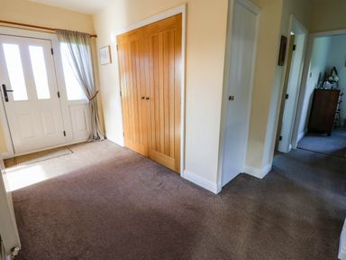 A hallway with a front door and closet at The Bungalow in Penrith