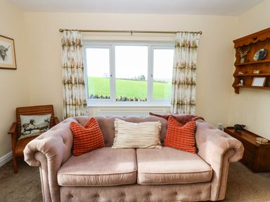 A living room with a sofa and a window at The Bungalow in Penrith
