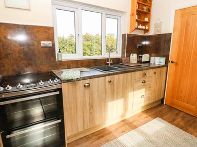 A kitchen with an oven, sink, and cabinets at The Bungalow in Penrith