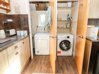 A utility room with washing machine and dryer at The Bungalow in Penrith
