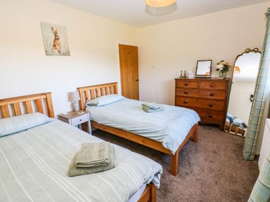 A bedroom with two beds and a dresser at The Bungalow in Penrith