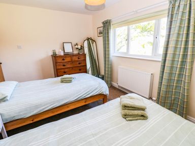 A bedroom with two beds and a dresser at The Bungalow in Penrith