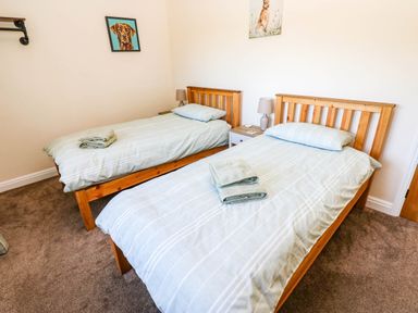 A bedroom with two single beds and a bedside table at The Bungalow in Penrith