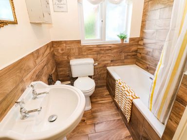 A bathroom with a washing basin toilet and bathtub at The Bungalow in Penrith