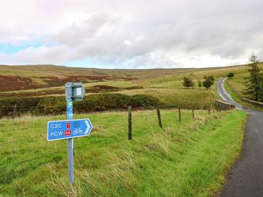 A signpost at a road junction in a hilly area at The Bungalow in Penrith