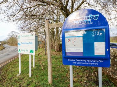 A signpost with information for community park and swimming pool at Lazonby Pool Penrith