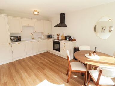 A kitchen with appliances and a dining table at Flat 2 in Tenby