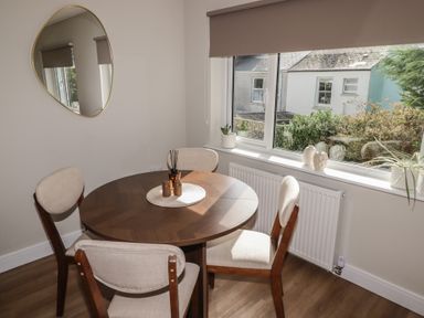 A dining room with a round table and chairs at Flat 2 in Tenby