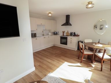 A kitchen with a dining table and chairs at Flat 2 in Tenby