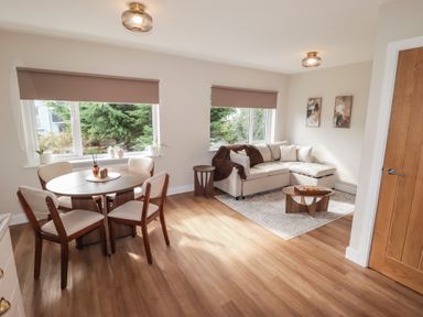 A living room with a sofa and dining table at Flat 2 in Tenby