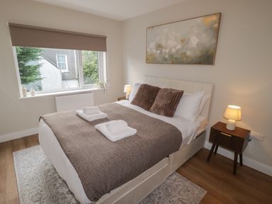 A bedroom with a bed and lamp at Flat 2 in Tenby