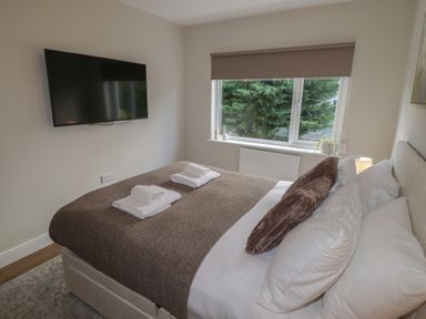 A bedroom with a bed and television at Flat 2 in Tenby