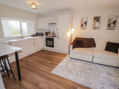 A kitchen with a couch and a dining area at Flat 3 in Tenby