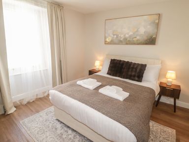 A bedroom with a bed and bedside tables at Flat 3 in Tenby