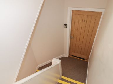 A stairway with a door labeled 3 at Flat 3 in Tenby