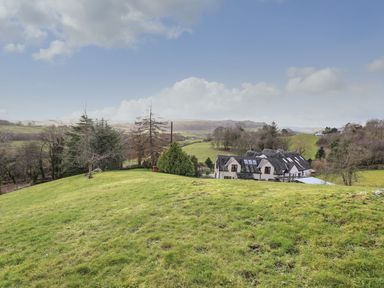 An outdoor view of a house and landscape at High Beck Cottage in Kendal