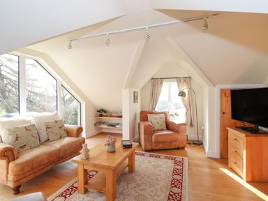 A living room with a sofa and armchair at High Beck Cottage in Kendal
