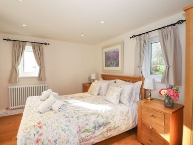 A bedroom with a bed and nightstands at High Beck Cottage in Kendal