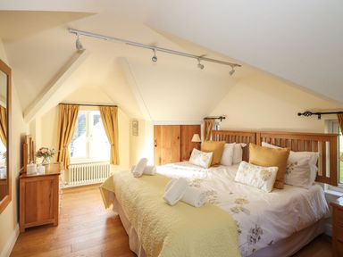 A bedroom with a bed and dresser at High Beck Cottage in Kendal