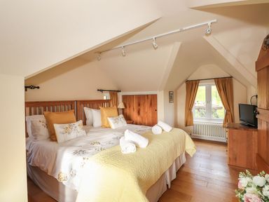 A bedroom with a double bed and window at High Beck Cottage in Kendal
