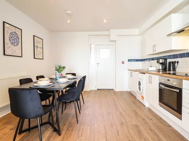 A kitchen with a dining table and chairs at Flat 4 Greenfields in Barmouth