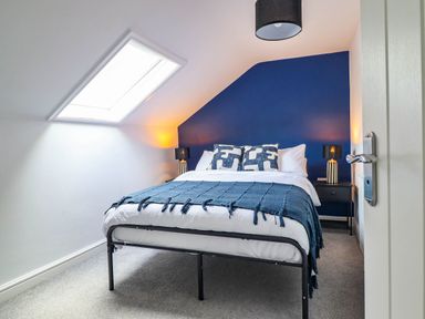 A bedroom with a bed and nightstand at Flat 4 Greenfields Barmouth