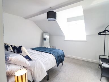 A bedroom with a bed and mirror at Flat 4 Greenfields Barmouth