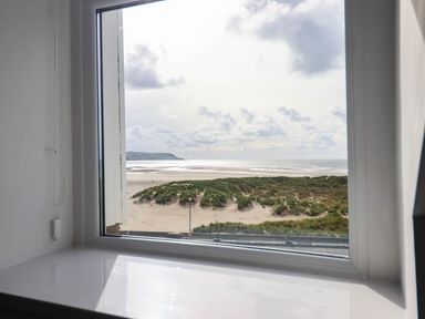 A view from a window showing beach and sea at Flat 4 Greenfields Barmouth