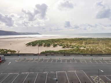 A beach with sand dunes and an ocean view at Flat 4 Greenfields Barmouth