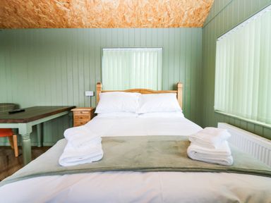 A bedroom with a bed and a table at Calendonia Hut, West Mains near Haggerston
