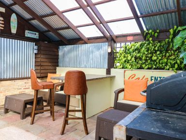 An outdoor seating area with bar stools and a grill at Calendonia Hut West Mains near Haggerston
