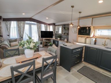 A living room with a sofa and dining area at 19 Finch