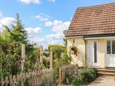 A house with a front door and garden at Merlins Hideaway in Dawlish