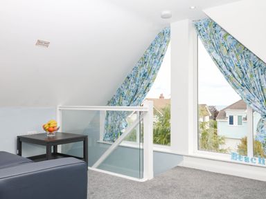 A loft area with a table and fruit bowl at Merlins Hideaway in Dawlish