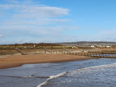 A beach with a sea wall and steps leading to the coastline at Merlins Hideaway, Dawlish