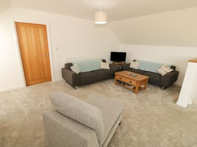 A living room with a sofa and television at Cae Mawr in Caernarfon